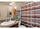 Neutral bathroom featuring a single sink, and desert-themed shower curtain and chrome shelving at 8421 E Main St # 116, Mesa, AZ 85207