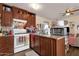 Cozy kitchen with wood cabinets, white appliances, and homey décor at 8421 E Main St # 116, Mesa, AZ 85207