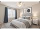 This bedroom has a ceiling fan, large windows with white shutters and blue curtains at 9212 W Salter Dr, Peoria, AZ 85382