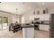 Bright kitchen with stainless steel appliances, a black island, and sliding door access to the backyard pool area at 9212 W Salter Dr, Peoria, AZ 85382
