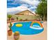 Backyard pool area with tanning deck and desert landscaping, including rainbow and yellow floats at 9212 W Salter Dr, Peoria, AZ 85382