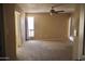 Spacious bedroom with neutral carpeting, a ceiling fan, and ample natural light from a large window at 10326 W Harmont Dr, Peoria, AZ 85345