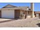 Side view of the property, showing brickwork, a two-car garage and desert landscaping at 10326 W Harmont Dr, Peoria, AZ 85345