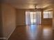 A spacious living room with tile flooring, ceiling fan, and a sliding glass door to the outside at 10326 W Harmont Dr, Peoria, AZ 85345