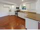 Bright kitchen featuring white cabinets, hardwood floors, stainless steel appliances, and laminate countertops at 1048 E 6Th Ave, Mesa, AZ 85204