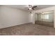 Spacious carpeted bedroom featuring sliding mirror closet doors and a ceiling fan at 1066 Leisure World --, Mesa, AZ 85206