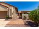 Tan home exterior featuring desert landscaping, wrought iron gate, and a tile walkway at 1066 Leisure World --, Mesa, AZ 85206