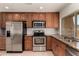 Modern kitchen with wood cabinets, granite countertops, stainless steel appliances, and a decorative backsplash at 1066 Leisure World --, Mesa, AZ 85206