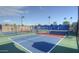 Outdoor pickleball courts feature blue and red surfaces, surrounded by fencing, under a clear blue sky at 1087 Leisure World --, Mesa, AZ 85206