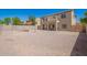 A spacious backyard features gravel landscaping and a shade sail, perfect for outdoor relaxation and enjoyment at 1120 E Jahns Dr, Casa Grande, AZ 85122
