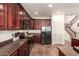 Well-lit kitchen features dark wood cabinetry, black appliances, and tile flooring at 1120 E Jahns Dr, Casa Grande, AZ 85122