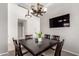 Open dining room with a dark wood table set, statement lighting, and TV at 15811 N 155Th Dr, Surprise, AZ 85374