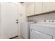 Laundry room with washer, dryer, cabinets, and exterior door at 15811 N 155Th Dr, Surprise, AZ 85374