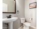 Powder room featuring a pedestal sink, toilet, neutral walls, and decorative art at 15811 N 155Th Dr, Surprise, AZ 85374