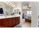Bathroom showcasing double sinks with wood cabinets, and a connecting view into a bedroom at 1662 E Kingman Pl, Casa Grande, AZ 85122