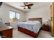 Comfortable bedroom featuring a large window and a wooden dresser, with a ceiling fan at 1662 E Kingman Pl, Casa Grande, AZ 85122