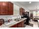 Functional kitchen featuring dark wood cabinets, granite countertops, and modern black appliances at 1662 E Kingman Pl, Casa Grande, AZ 85122