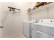 Well-lit laundry room featuring a washer, dryer, and storage shelves for convenience at 1662 E Kingman Pl, Casa Grande, AZ 85122