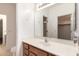 This bathroom boasts a large mirror, plenty of counter space, and wooden cabinets at 17562 W Gelding Dr, Surprise, AZ 85388
