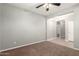 Bedroom showcasing neutral walls, a ceiling fan, and a doorway at 17562 W Gelding Dr, Surprise, AZ 85388