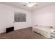 This bedroom features light pink walls, a ceiling fan, and a large window at 17562 W Gelding Dr, Surprise, AZ 85388