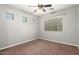 This bedroom features neutral walls, a ceiling fan and a large window at 17562 W Gelding Dr, Surprise, AZ 85388