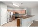 Bright kitchen with tile flooring, stainless steel appliances, wood cabinets, and peninsula at 17562 W Gelding Dr, Surprise, AZ 85388