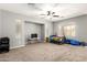 Open-concept living room with neutral tones, carpet flooring, and a ceiling fan at 17562 W Gelding Dr, Surprise, AZ 85388