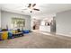 Bright living room showcasing neutral paint, plush carpeting, and open floor plan into the kitchen at 17562 W Gelding Dr, Surprise, AZ 85388