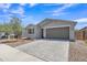 A modern stucco house with a paver driveway, desert landscaping, and a two-car garage at 1960 N Loretta Pl, Casa Grande, AZ 85122
