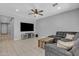 Open-concept living room with tile flooring, ceiling fan, comfortable seating, and a large television at 1960 N Loretta Pl, Casa Grande, AZ 85122