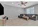 Bright living room featuring tile flooring, ceiling fan, and a comfortable gray sectional sofa at 1960 N Loretta Pl, Casa Grande, AZ 85122