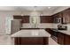 Well-lit kitchen featuring dark wood cabinets, an island, quartz countertops, and stainless appliances at 2000 N 36Th St # 14, Phoenix, AZ 85008