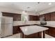 Contemporary kitchen with stainless appliances, quartz counters, dark wood cabinetry, and island at 2000 N 36Th St # 14, Phoenix, AZ 85008