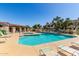 Community pool with lounge chairs surrounded by lush landscaping and clear blue sky at 2020 W Union Hills Dr # 156, Phoenix, AZ 85027