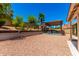 The backyard has lush landscaping, trees, a patio, pergola, rock landscape, and a block wall for privacy at 2109 E Gelding Dr, Phoenix, AZ 85022