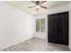 Bright bedroom with a ceiling fan, new plank flooring, and black closet, and a window with a tree view at 2109 E Gelding Dr, Phoenix, AZ 85022