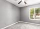 Neutral-toned bedroom featuring a ceiling fan and a bright window with a view of greenery at 2109 E Gelding Dr, Phoenix, AZ 85022