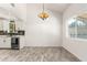 Bright dining area with vaulted ceilings, wood-look floors, and updated lighting near the modern kitchen at 2109 E Gelding Dr, Phoenix, AZ 85022