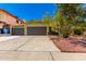 Inviting curb appeal with a green home exterior, flowering tree, three car garage and well-manicured landscaping at 2109 E Gelding Dr, Phoenix, AZ 85022
