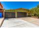 Attractive curb appeal featuring a three car garage, green home, and well-maintained landscaping at 2109 E Gelding Dr, Phoenix, AZ 85022