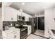 Updated kitchen showcasing stainless steel appliances, white cabinets, and stylish backsplash at 2109 E Gelding Dr, Phoenix, AZ 85022