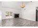 Spacious living room with wood-look flooring, fireplace, beamed ceiling, and sliding door access to the patio at 2109 E Gelding Dr, Phoenix, AZ 85022