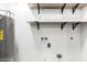 Functional utility area with a water heater, shelving, and designated space for laundry appliances at 2109 E Gelding Dr, Phoenix, AZ 85022