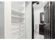 This walk-in closet features custom built-in shelving and drawers with a view into the en-suite bath at 2109 E Gelding Dr, Phoenix, AZ 85022