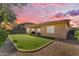 Beautiful backyard featuring artificial turf, patio area and mature trees under a colorful sky at 2459 E Lindrick Dr, Gilbert, AZ 85298