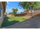 Lush artificial turf provides a perfect backdrop to the backyard with mature tree and block wall at 2459 E Lindrick Dr, Gilbert, AZ 85298
