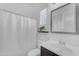 Bright bathroom features a modern vanity, white shower curtain, shuttered window and contemporary fixtures at 2459 E Lindrick Dr, Gilbert, AZ 85298