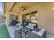 Spacious covered patio with ceiling fan, outdoor furniture, barbecue grill and a view of artificial grass at 2459 E Lindrick Dr, Gilbert, AZ 85298