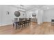 Bright dining room features wood floors, an oversized clock, and a modern chandelier at 2459 E Lindrick Dr, Gilbert, AZ 85298